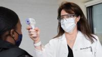 doctor checking temperature of a patient